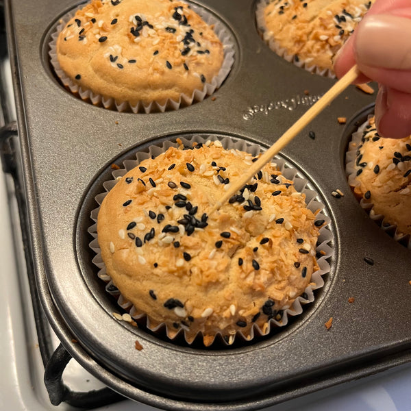 checking to see if the muffins are done by inserting a toothpick in the middle